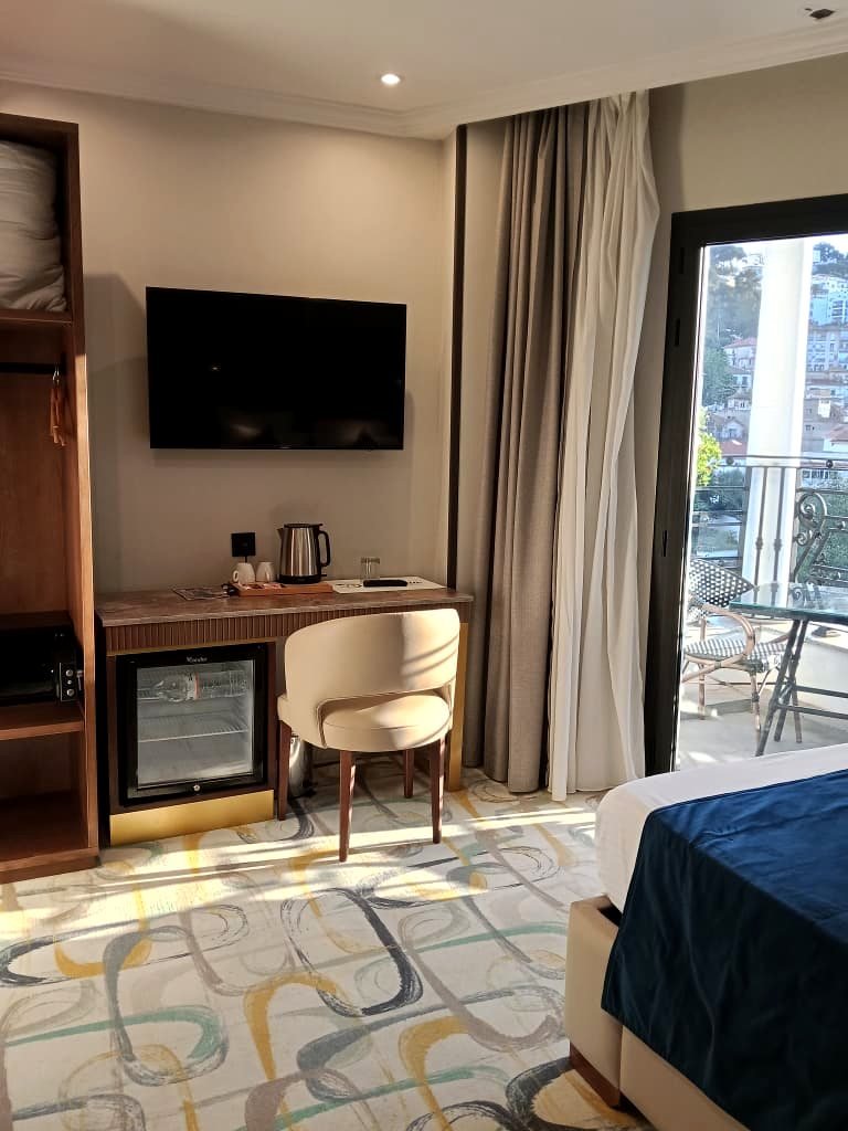 Chambre avec balcon de l'Hôtel Printania à Alger, porte-fenêtre ouverte sur les toits de Telemly