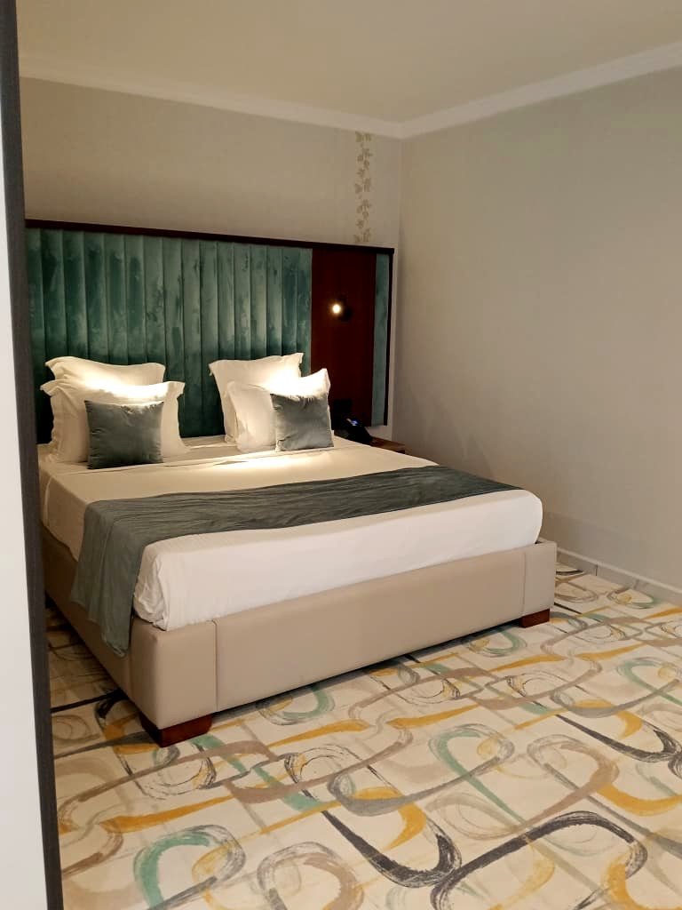 Chambre double de l'Hôtel Printania à Alger, grand lit et tête de lit en velours vert