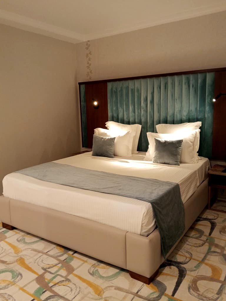 Chambre double de l'Hôtel Printania à Alger, grand lit et tête de lit en velours vert