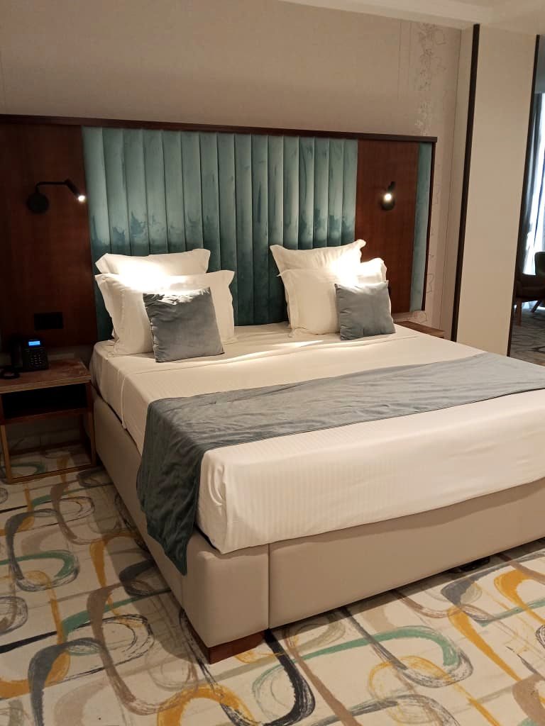Chambre double de l'Hôtel Printania à Alger, grand lit et tête de lit en velours vert