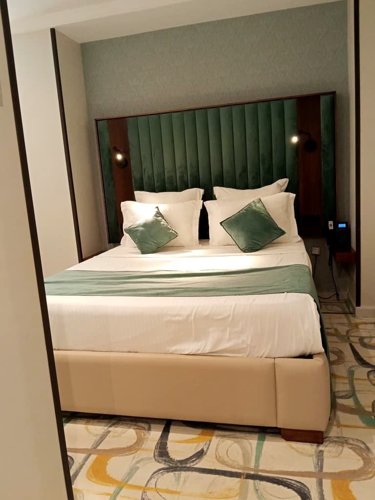 Chambre double de l'Hôtel Printania à Alger, grand lit et tête de lit en velours vert