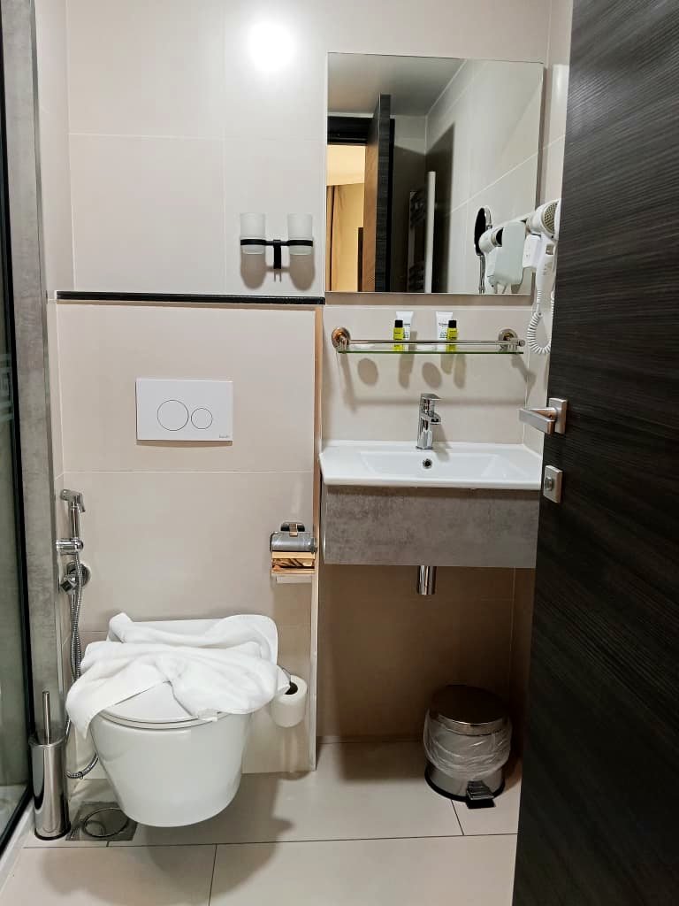 Chambre avec balcon de l'Hôtel Printania à Alger, porte-fenêtre ouverte sur les toits de Telemly